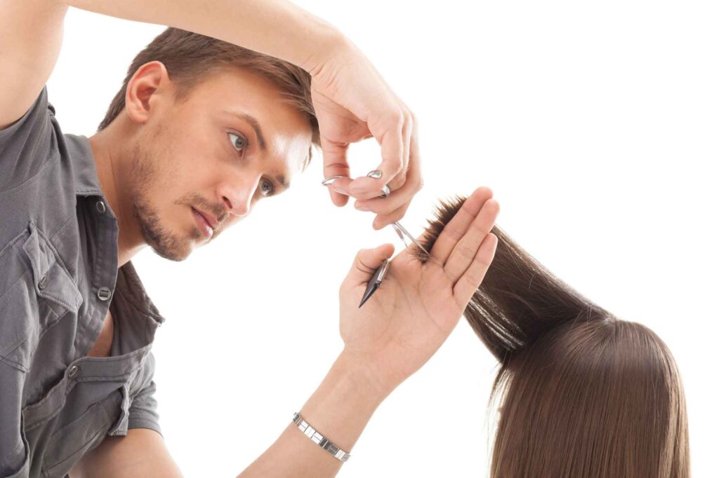 Ein Friseur beim Haare schneiden.
